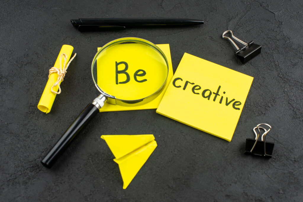 bottom-view-be-creative-written-yellow-sticky-note-lupa-binder-clips-pen-dark-background-1024x683 How to Build a Personal Brand That Sells for You